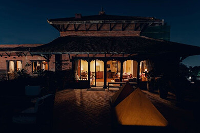 Traditional Newari pavilion illuminated at twilight with fire pit