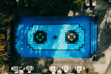 Aerial view of geometric patterned swimming pool with sun loungers