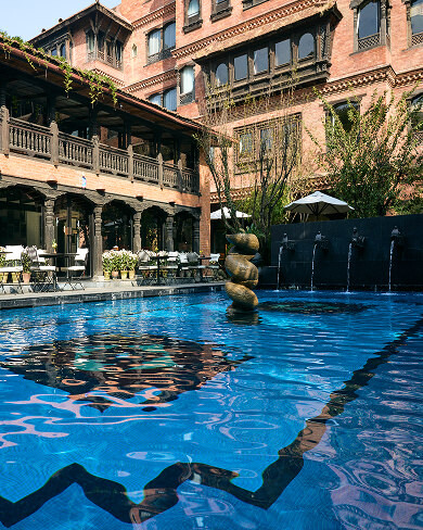 Swimming pool with heritage Newari architecture and stone sculpture fountain